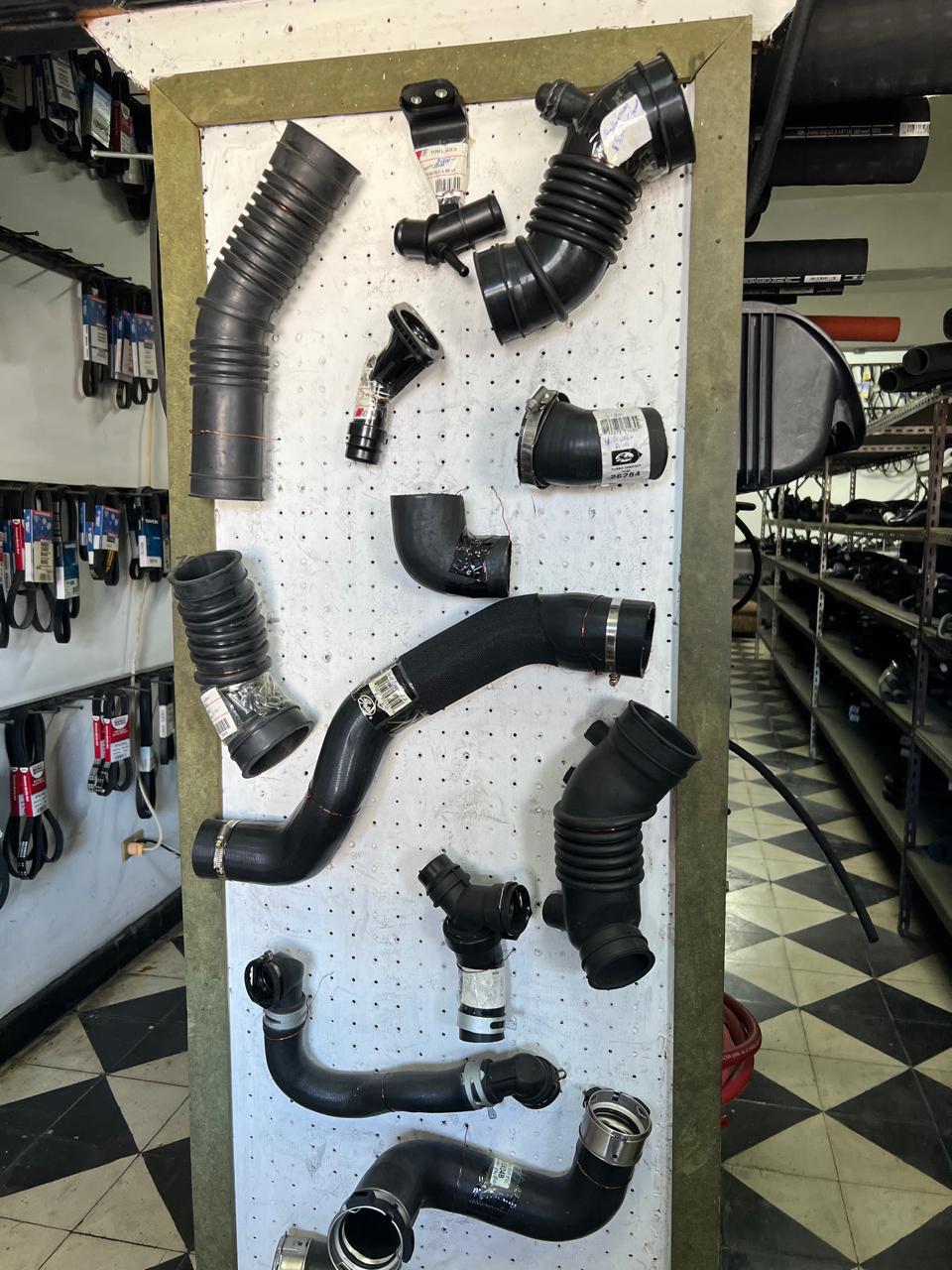Pared de exhibición con mangueras de turbo y radiador organizadas en Importadora Saviñon
